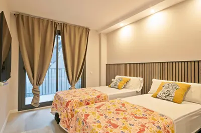a hotel room with two beds and a window at YOUR HOME- Apartment Camp Nou Baj in Hospitalet de Llobregat