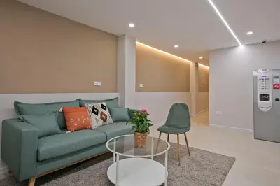 a living room with a green couch and a table at YOUR HOME- Apartment Camp Nou 1 in Hospitalet de Llobregat
