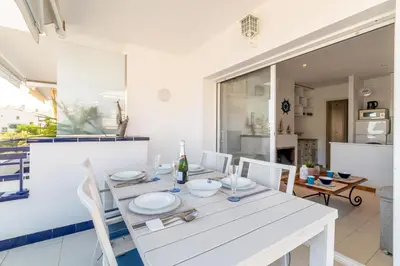 a white dining room with a white table and chairs at Romantic: Precioso frente al mar in Sitges