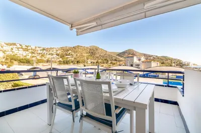 a white dining table and chairs on a balcony with a view at Romantic: Precioso frente al mar in Sitges