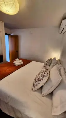 a bedroom with a white bed with a pillow at Vila Sitges, big house with pool in Sitges