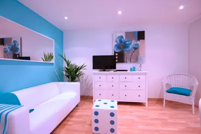 a living room with a white couch and a tv at Cosmopolitan in Barcelona
