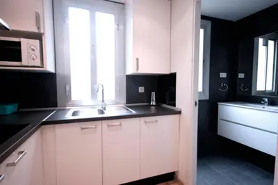 a kitchen with white cabinets and a sink and a window at Cosmopolitan in Barcelona
