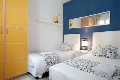 a bedroom with two beds and a mirror on the wall at Rainbow in Barcelona