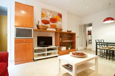 a living room with a tv and a table at Rainbow in Barcelona