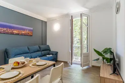 a living room with a blue couch and a table at AB Marina Apartments in Barcelona