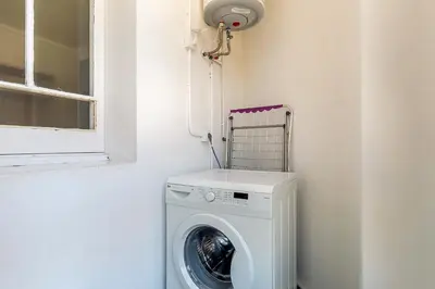 a washing machine in a corner with a window at AB Marina Apartments in Barcelona
