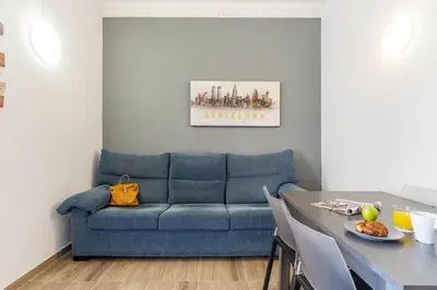 a living room with a blue couch and a table at AB Marina Apartments in Barcelona