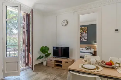 a white living room with a table and a television at AB Marina Apartments in Barcelona