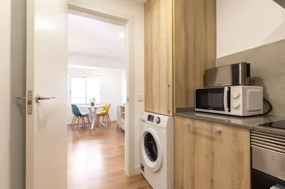 a kitchen with a washing machine and a microwave at Picasso Suites Cornellá in Cornellà de Llobregat