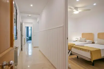 a bedroom with two beds and a hallway at Anton's Downtown Apartment in Barcelona
