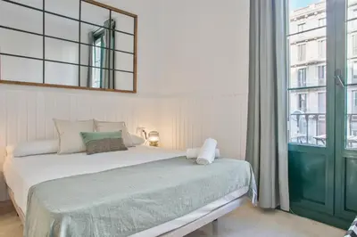 a bedroom with a bed and a large window at Anton's Downtown Apartment in Barcelona
