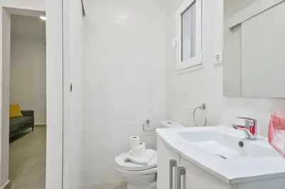 a white bathroom with a toilet and a sink at Alcam Baro 22 in Barcelona