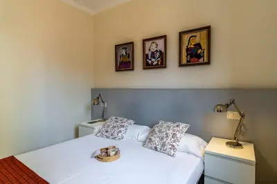 two beds in a room with pictures on the wall at 2098 - AB Sagrada Família Bofill in Barcelona