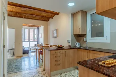 a kitchen with wooden cabinets and a dining room at 2098 - AB Sagrada Família Bofill in Barcelona