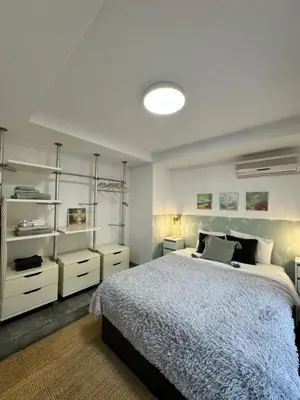a bedroom with a bed and some white shelves at Private terrace 1BR apt - 4min walk to the beach in Pineda de Mar