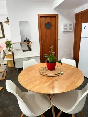 a dining room with a wooden table and white chairs at Private terrace 1BR apt - 4min walk to the beach in Pineda de Mar