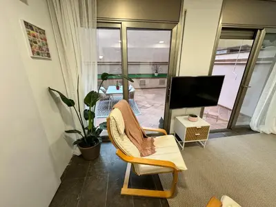 a living room with a chair and a flat screen tv at Private terrace 1BR apt - 4min walk to the beach in Pineda de Mar