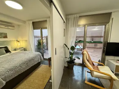 a bedroom with a bed and a view of a patio at Private terrace 1BR apt - 4min walk to the beach in Pineda de Mar