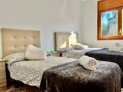 a hotel room with two beds and a towel on the bed at Amplio Apartamento, 5 camas in Sant Esteve Sesrovires