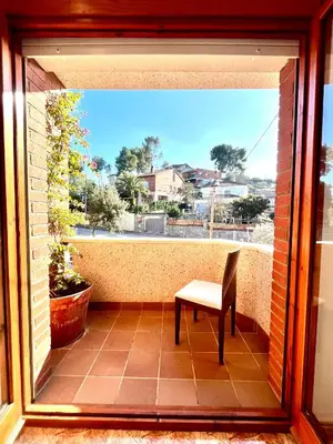 a chair sitting on a balcony with a view at Amplio Apartamento, 5 camas in Sant Esteve Sesrovires