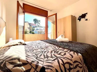 a bedroom with a large bed with a large window at Amplio Apartamento, 5 camas in Sant Esteve Sesrovires
