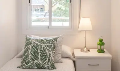 a bedroom with a bed with a pillow and a window at Lets Holidays Castelldefels Diagonal Orient in Castelldefels