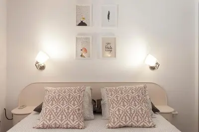 a bedroom with a bed with two pillows and two lights at Lets Holidays Castelldefels Diagonal Orient in Castelldefels