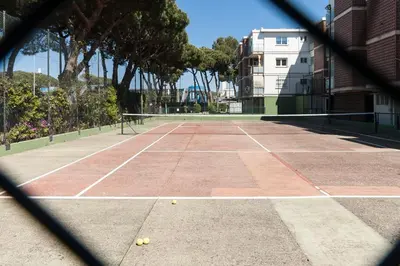 a tennis court with two tennis balls on it at Lets Holidays Castelldefels Diagonal Orient in Castelldefels