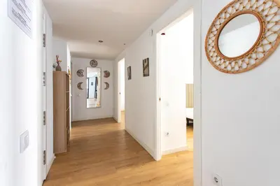 a hallway with white walls and a mirror on the wall at StayCampNou 3BR With Balcony in Hospitalet de Llobregat