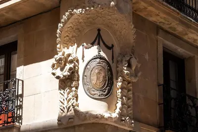 a clock on the side of a building at Casa Pince in Barcelona