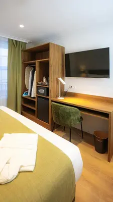 a hotel room with a bed and a desk with a television at Casa Pince in Barcelona