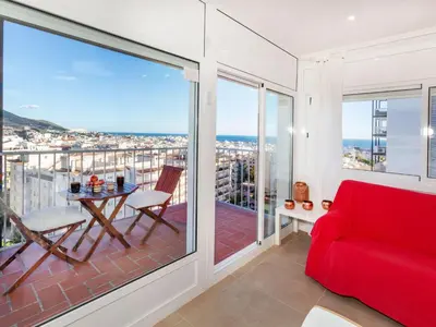 a living room with a red couch and a balcony at Apartment Cortijo Barques by Interhome in Sitges