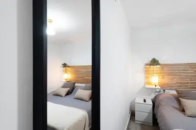 a bedroom with two beds and a mirror at Apartamento Luna in Montgat