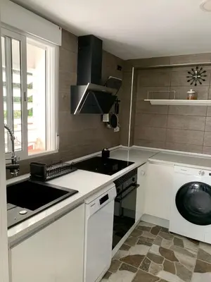 a white kitchen with a sink and a dishwasher at Puig comfort in Calella
