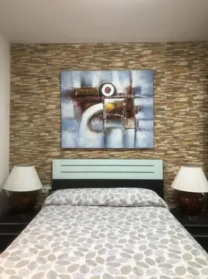 a bedroom with a bed and two lamps and a painting at Apartamento Villa Caracol in Cunit