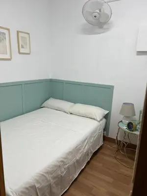 a bedroom with a white bed with a light above it at Apartamento Villa Caracol in Cunit