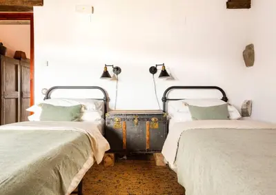 an old suitcase sitting between two beds in a room at Masía espectacular cerca de Barcelona in Granera