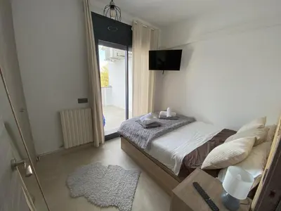 a bedroom with a bed and a tv and a window at Villa privada para grupos grandes cerca de Sitges Piscina terrazas y naturaleza in Olivella