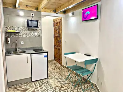 a kitchen with a table and chairs and a sink at Estudio nuevo! Al lado del metro L1 L4 L5 in Barcelona