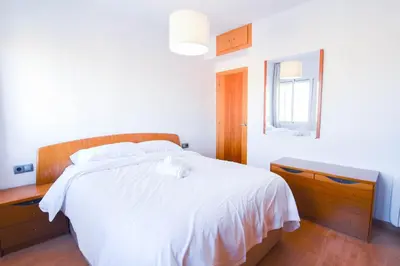 a bedroom with a white bed and a mirror at Touch the Sky in Hospitalet de Llobregat