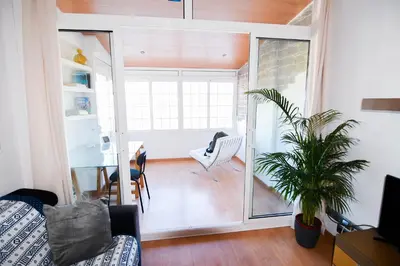 a living room with a couch and a plant at Touch the Sky in Hospitalet de Llobregat