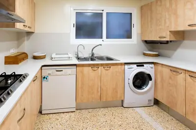 a kitchen with a washing machine and a sink at Niu d'Oreneta in Canet de Mar