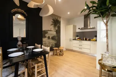 a kitchen and dining room with a black table and chairs at En Ville Boutique Apartments Tamarit in Barcelona