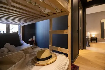 a hat is sitting on a bed in a room at En Ville Boutique Apartments Tamarit in Barcelona