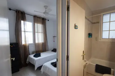 a bedroom with two beds and a tub and a window at Lovely house in Bellaterra (10 min to UAB) in Cerdanyola del Valles