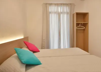 two pillows sitting on a bed in a bedroom at Apartamentos Olivier in Barcelona