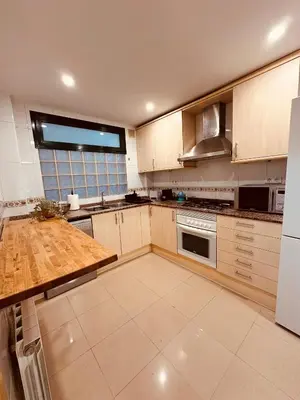 a large kitchen with a wooden counter top in it at DOLCE GAVA - Estación TREN in Gavà