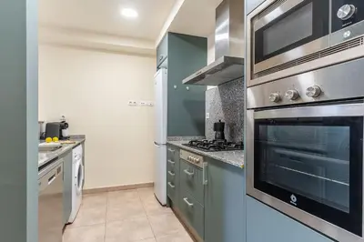 a kitchen with blue cabinets and a stove top oven at AB Sagrada Familia - Sant Pau in Barcelona