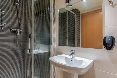 a bathroom with a sink and a shower with a mirror at AB Sagrada Familia - Sant Pau in Barcelona
